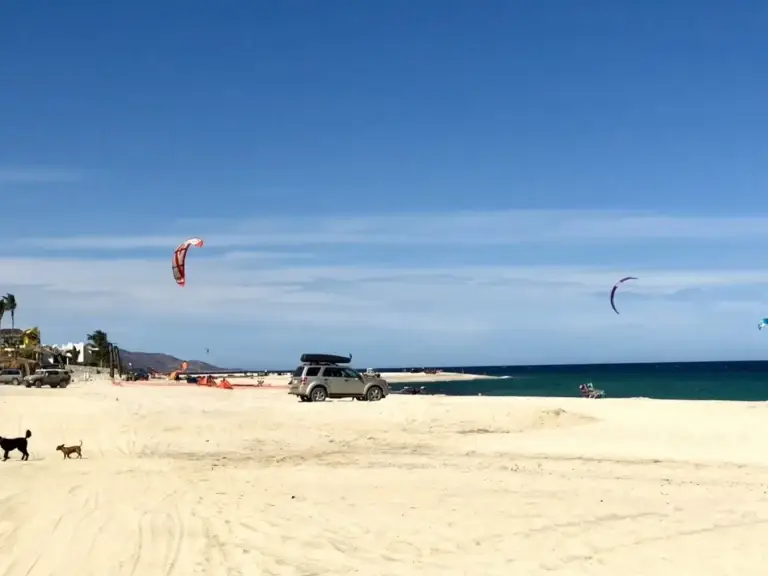 Kiteboarding kites over the white-sand beach at Los Barriles